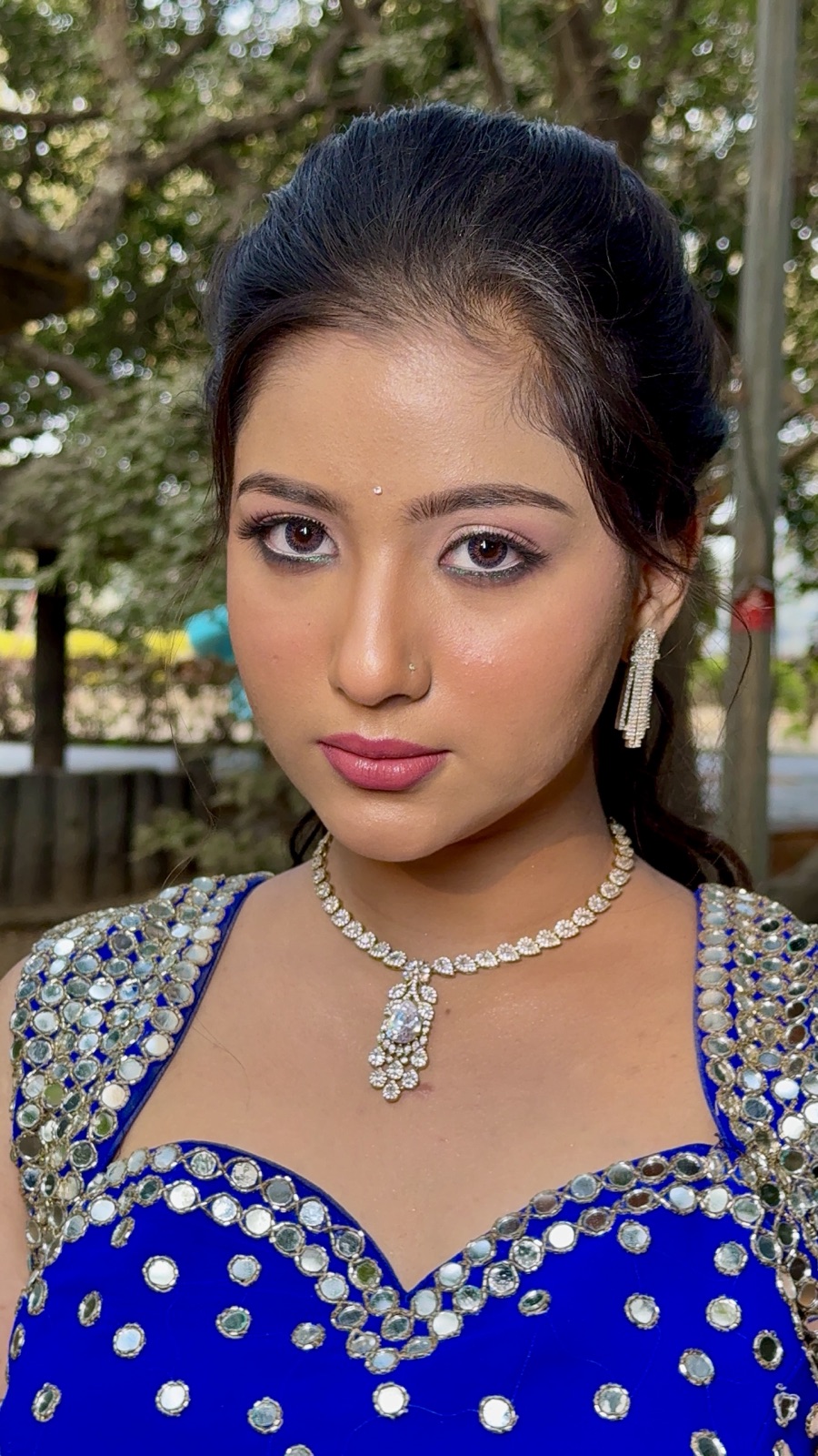 Party guest look with soft glam makeup and a blue embellished blouse